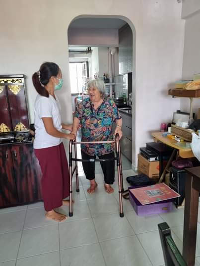 Helper assisting elderly with walker