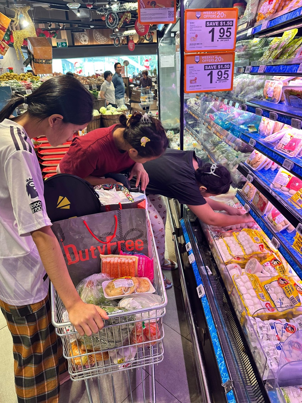 Helper at the supermarket with a loaded shopping cart