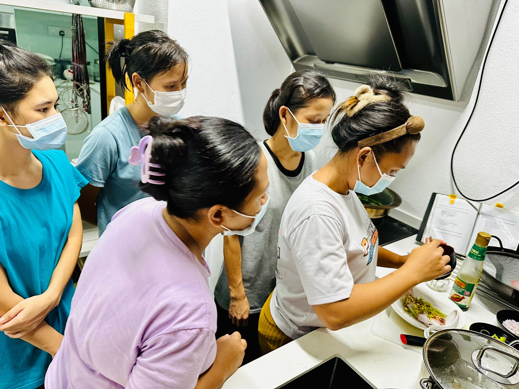Helpers cooking with recipe book during training